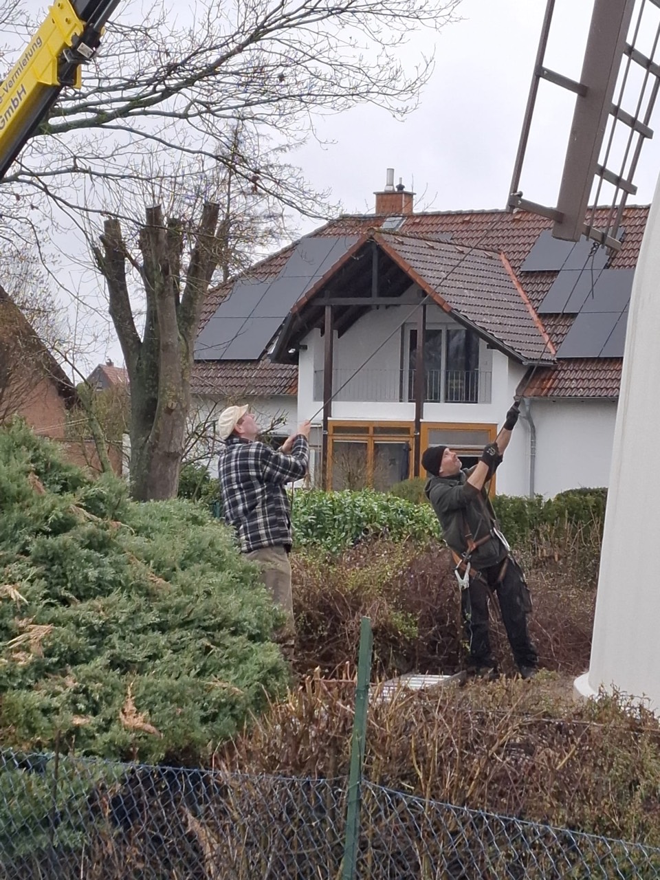 Onlookers watch the sail installation