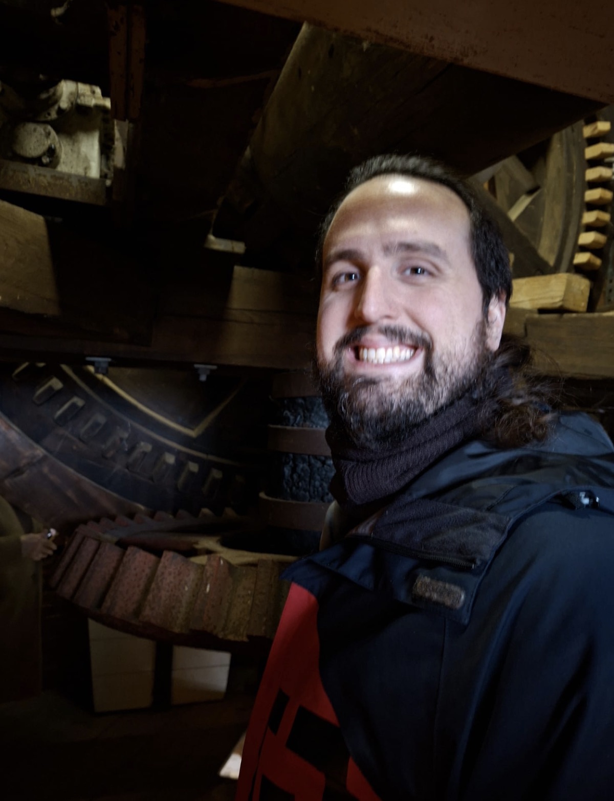 Un visitante junto al engranaje histórico del molino