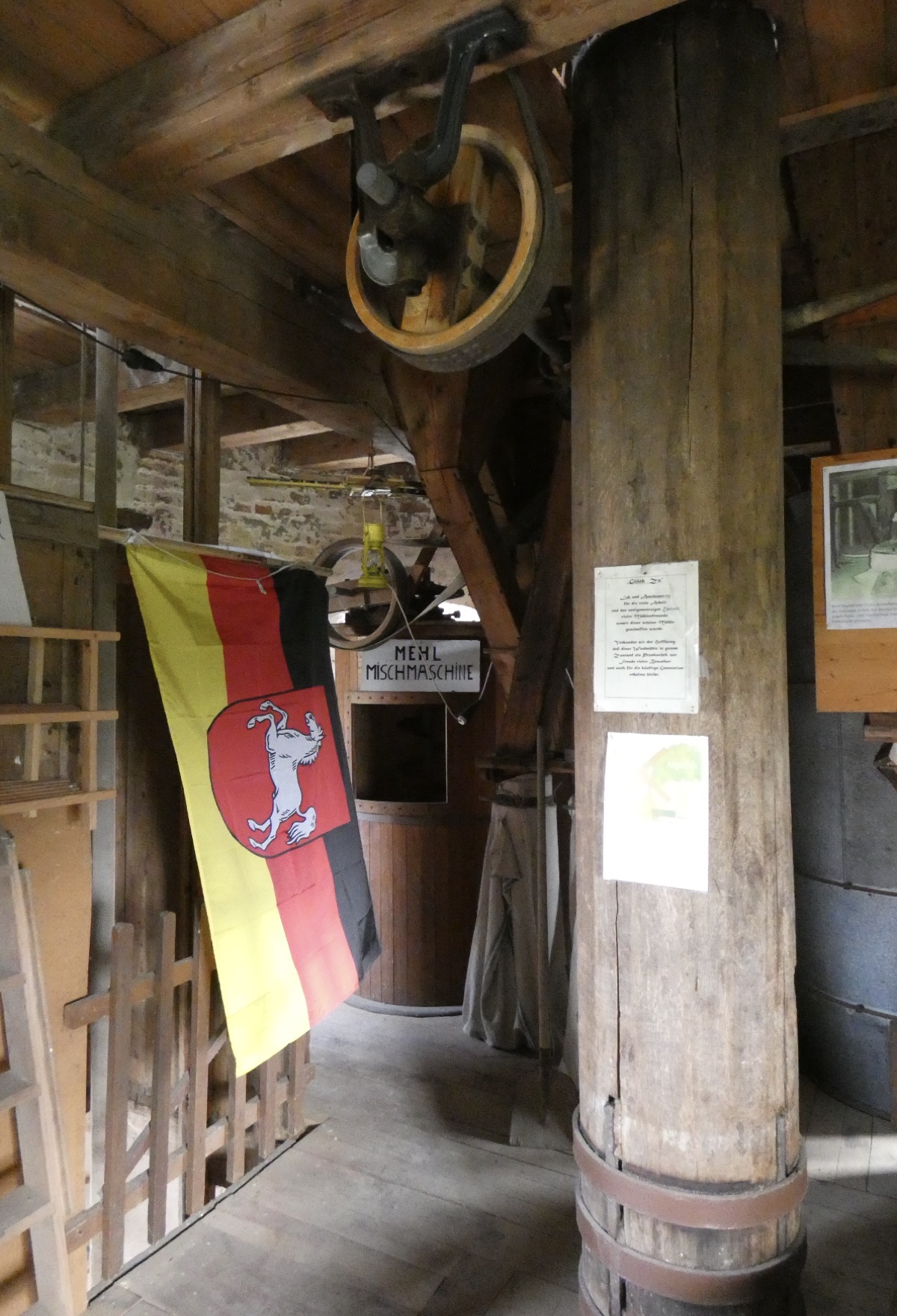 Interior del molino con la bandera de Baja Sajonia y la máquina mezcladora de harina