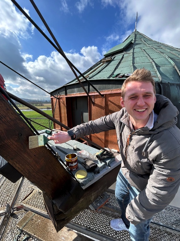 Handwerker auf der Mühlenkappe bei den Arbeiten an der Windrose